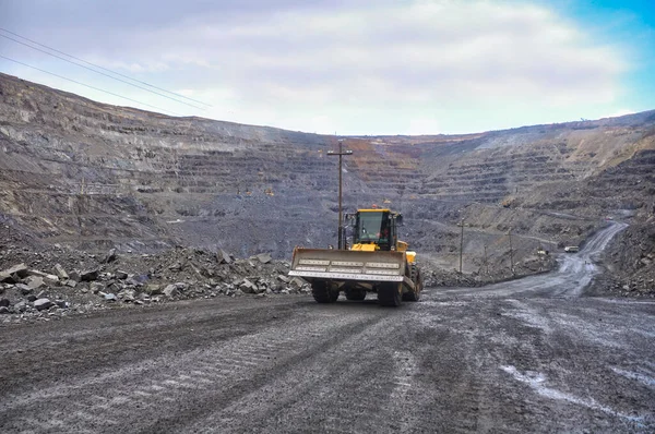 Tekerlekli buldozer demir madeninin yollarında ilerliyor.