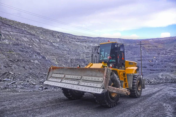 Tekerlekli buldozer demir madeninin yollarında ilerliyor.