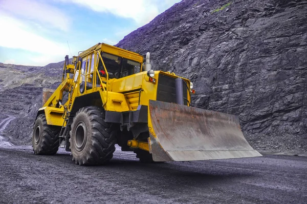 Tekerlekli buldozer demir madeninin yollarında ilerliyor.