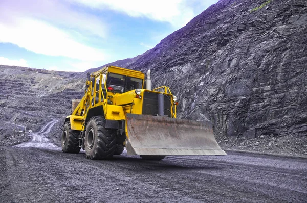 Tekerlekli buldozer demir madeninin yollarında ilerliyor.