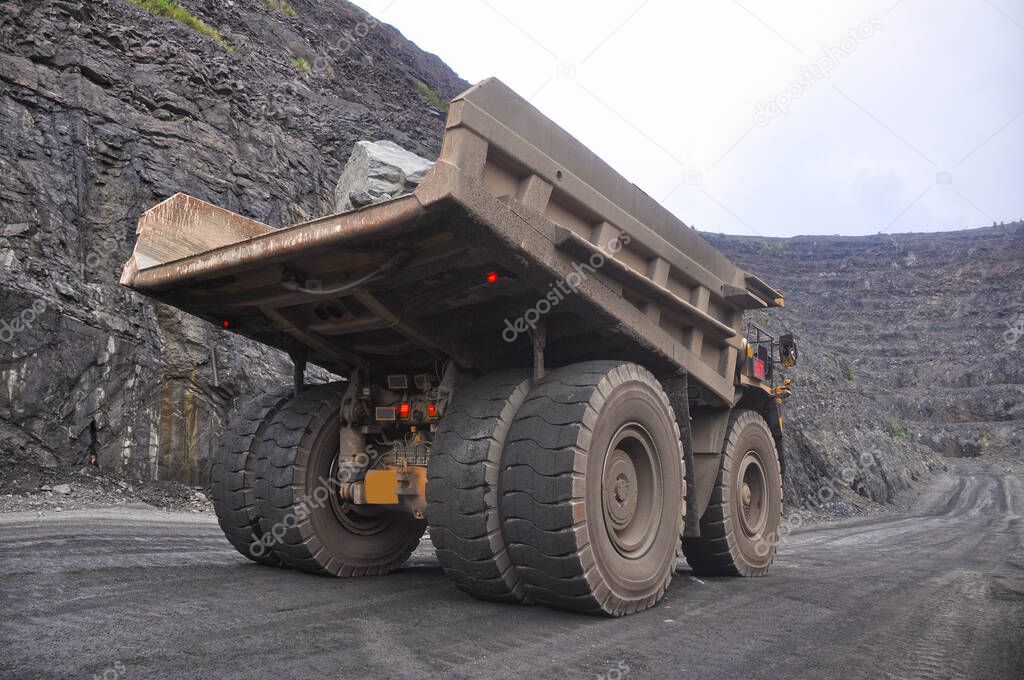 The work of a heavy quarry dump truck in the iron ore quarry.