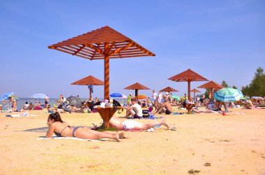 Ukrayna, Shatsk 22 Ağustos 2019. Svityaz Gölü kıyısında bir sahil. İnsanlar plajda güneşlenirken şemsiyelerle güneşleniyorlar.