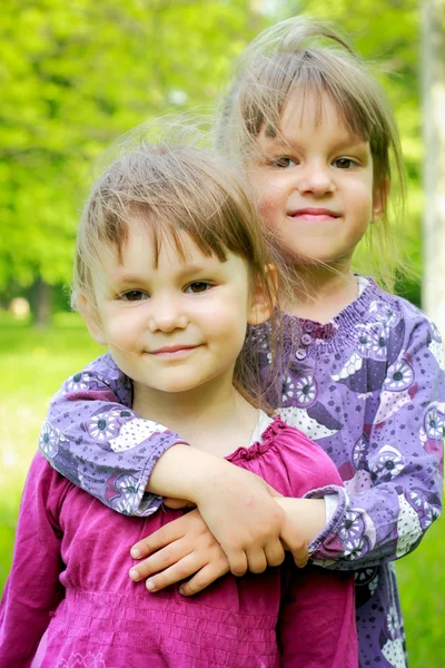 Dvě mladý, usměvavý dívky v trávě — Stock fotografie