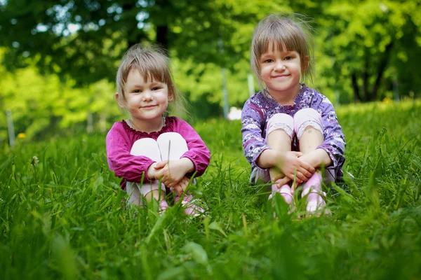 Duas jovens garotas sorridentes na grama — Fotografia de Stock