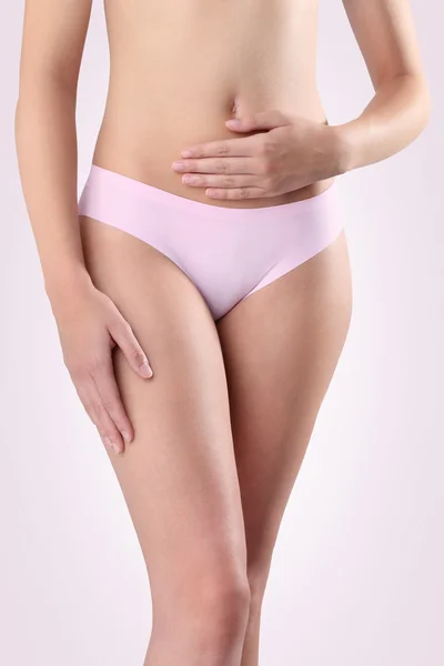 Woman's hands on stomach on pink backgroun — Stock Photo, Image