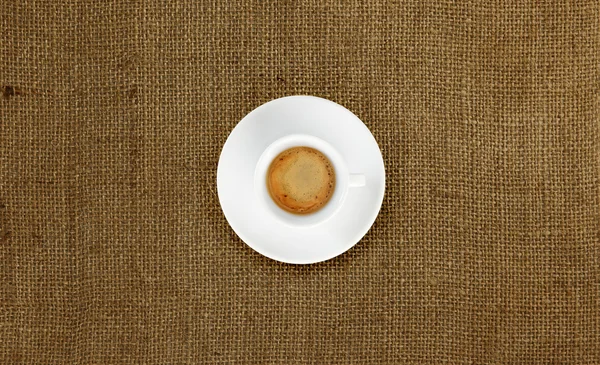 Cup of coffee on jute fabric — Stock Photo, Image