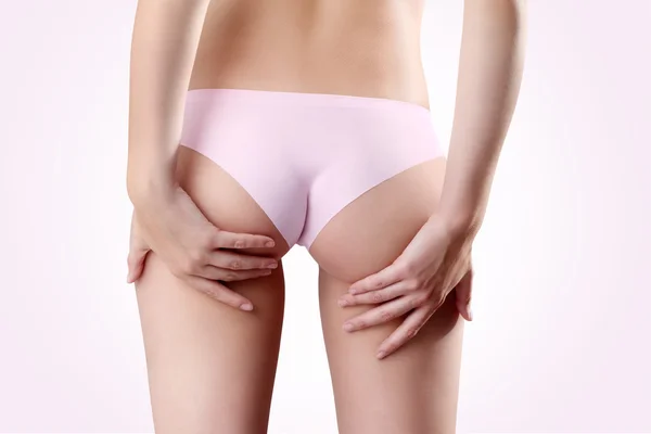 Bum et les jambes de la femme, les mains touchant les fesses sur bac rose — Photo