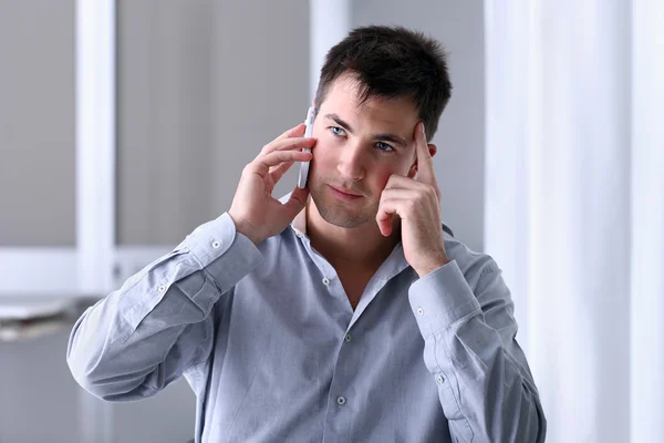 Fundersam man i telefon på kontoret — Stockfoto