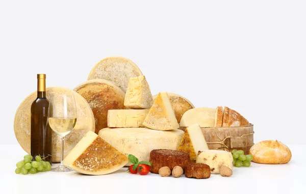 Various types of cheese with wine, grapes, tomatoes, basil and b — Stock Photo, Image