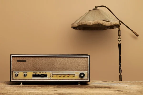 Staré rádio na dřevěný stůl s stojací lampa — Stock fotografie