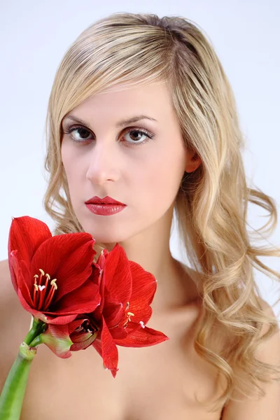 Beautiful blond girl with red amaryllis flower on a white backgr — Stock Photo, Image