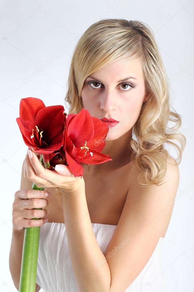 beautiful blond girl with red amaryllis flower on a white backgr
