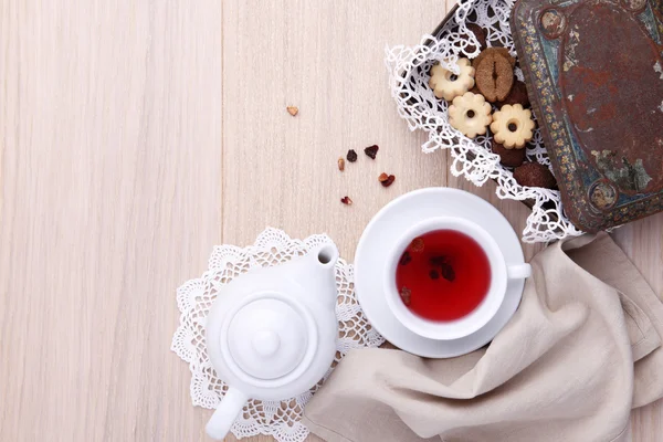 Mesa de madera para el desayuno con tetera taza de té y galletas — Foto de Stock