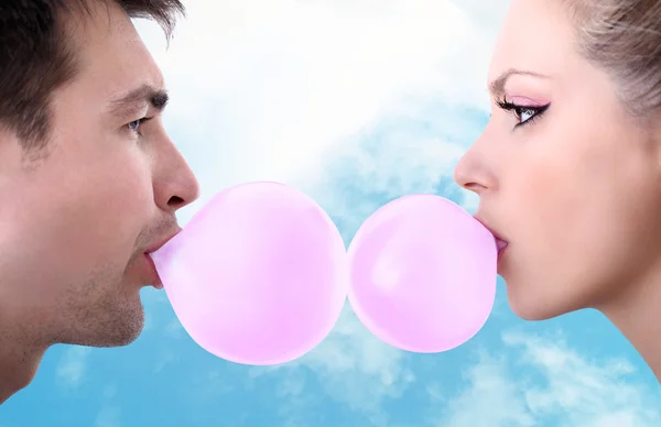 Joyeux jeune couple jouer avec chewing-gum — Photo