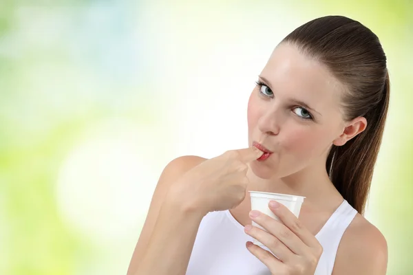 Schöne Mädchen essen Joghurt Finger lutschen — Stockfoto