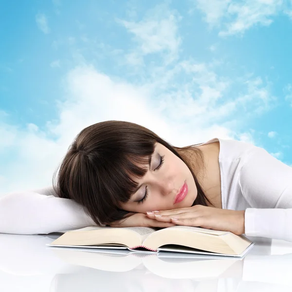 Arka plan gökyüzü bulutlu bir kitap ile uyuyan kız — Stok fotoğraf