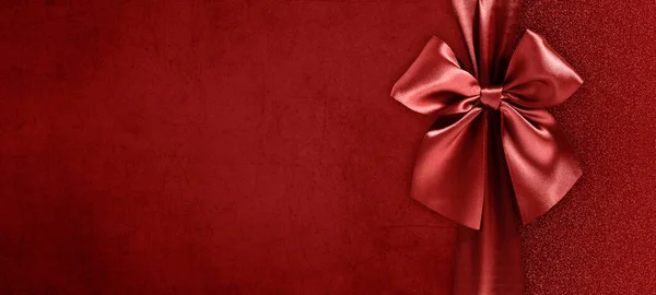 赤いリボンの弓が赤いきらびやかな背景に隔離された陽気なクリスマスギフトカード トップビューとコピースペーステンプレート バレンタインデーのレイアウト 最高の願いやタグ付けショッピング — ストック写真