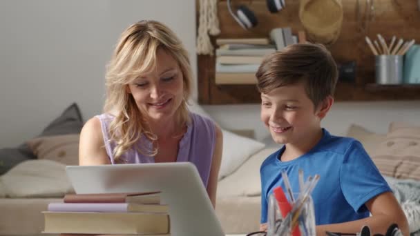 家里快乐 带着儿子微笑的母亲用电脑 在笔记本电脑上与人握手致意 舒服地坐在客厅里与父亲遥谈 — 图库视频影像