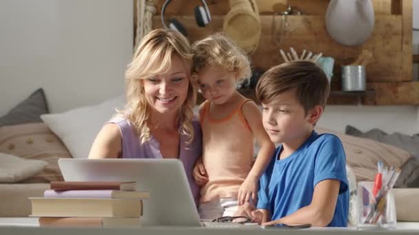 家里快乐的家庭 带着儿子和女儿的母亲在电脑上玩得开心 带着孩子们在笔记本电脑上上网 舒服地坐在客厅里与父亲进行远程交流 — 图库视频影像