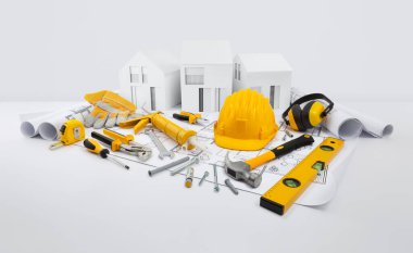 Ev inşa planı konsepti. İnşaat işleri için aletler. Mimari model evler, sarı başlık, çekiç, silikon tabanca, anahtarlar, kulaklıklar ve eldivenlerle planların üzerindeki parkmetre ve ruh seviyesi.