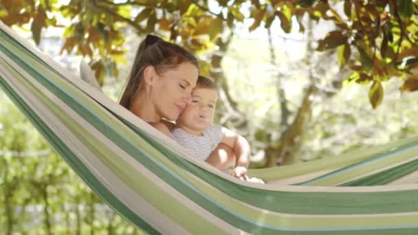 Gülümseyen Mutlu Anne Küçük Oğluna Sarılıyor Hamakta Birlikte Uzanarak Rahatlıyor — Stok video