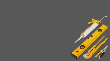 Construction work tools for building. Yellow hard hat with work equipment isolated on grey background. Layout for home service repair concept or hardware store showcase banner.Top view set of objects