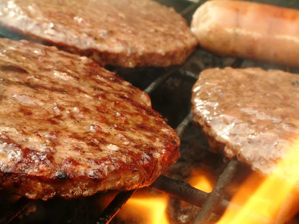 Hamburguesas cocinando en barbacoa — Foto de Stock