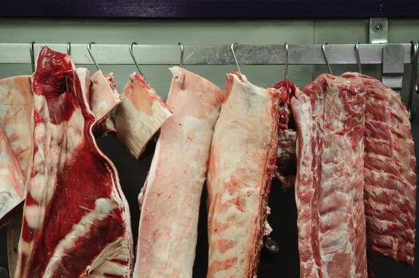 Carne masacrada colgando de ganchos — Foto de Stock
