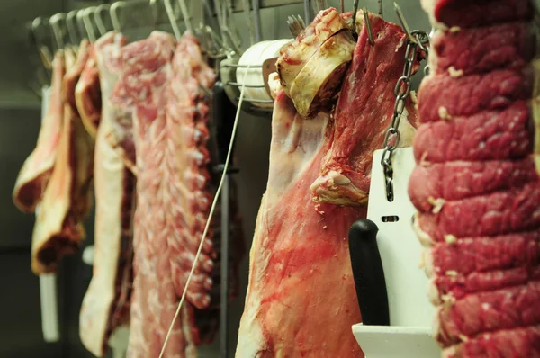 Carne masacrada colgando de ganchos — Foto de Stock