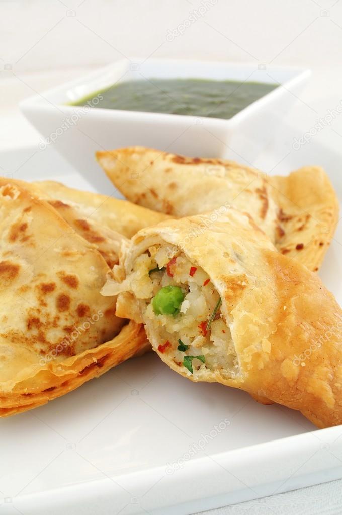 Vegetable samosas on white platter with Lal dip — Stock Photo