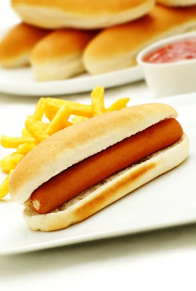 Traditional hot dog in bread roll and fries — Stock Photo, Image