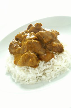 Karayipler style curried keçi ile haşlanmış pirinç beyaz plaka üzerinde