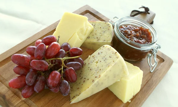 带有芥末籽、葡萄和胡桃木的奶酪 — 图库照片