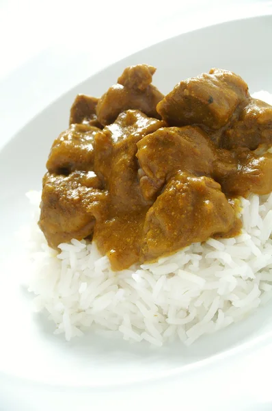 CHIVO al curry estilo caribeño con arroz hervido en placa blanca — 스톡 사진