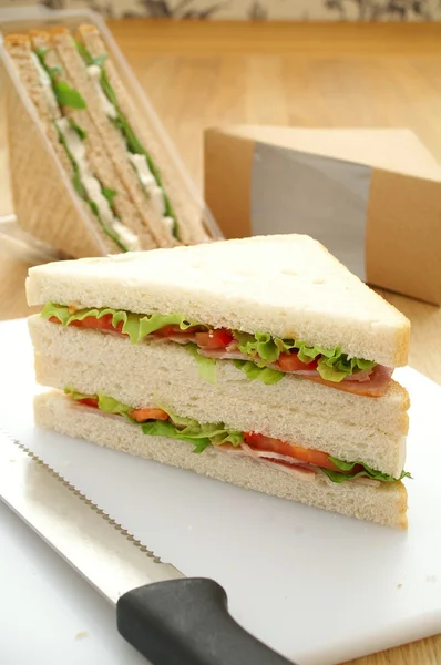 Cut ham sandwiches with packaging — Stock Photo, Image