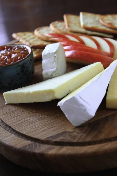 Queijo e outros produtos em mesa de madeira — Fotografia de Stock