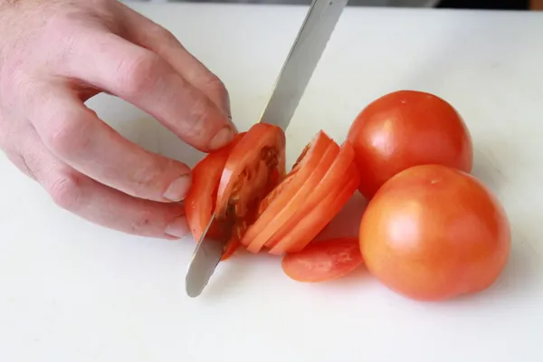 Kocken skivning tomat — Stockfoto