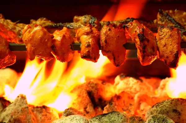 Chicken Tikka on spit cooked over charcoal barbecue — Stock Photo, Image