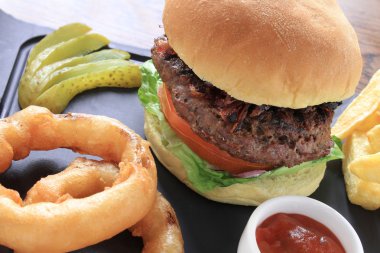 hamburger, patates kızartması ve soğan halkası ile bun