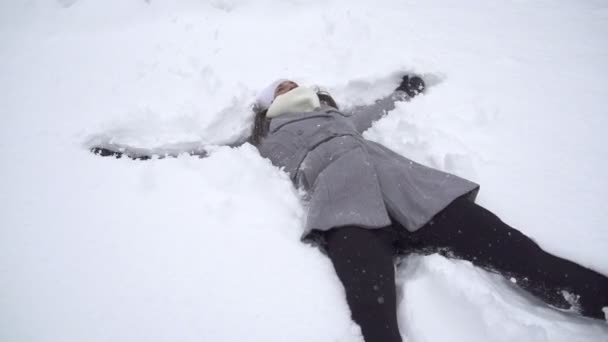 Mujer haciendo ángeles de nieve — Vídeos de Stock