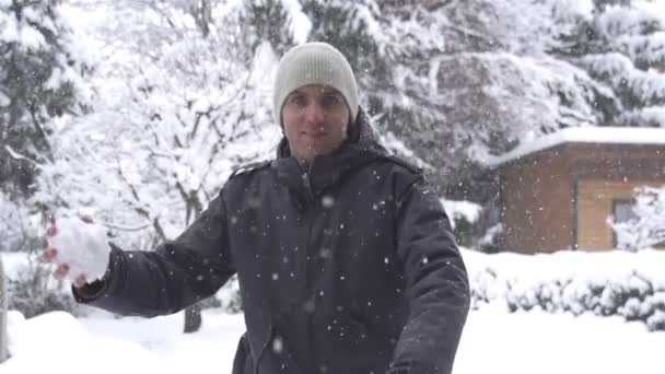Hombre lanzando una bola de nieve — Vídeos de Stock