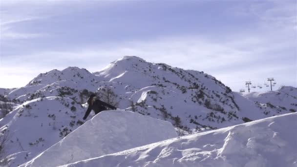 Snowboardåkare hoppa en kicker — Stockvideo