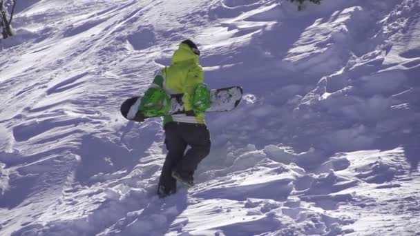 Snowboarder va cuesta arriba — Vídeo de stock