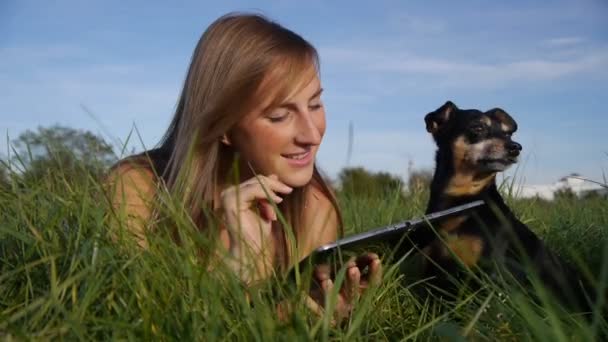 Menina com cão usando tablet digital — Vídeo de Stock