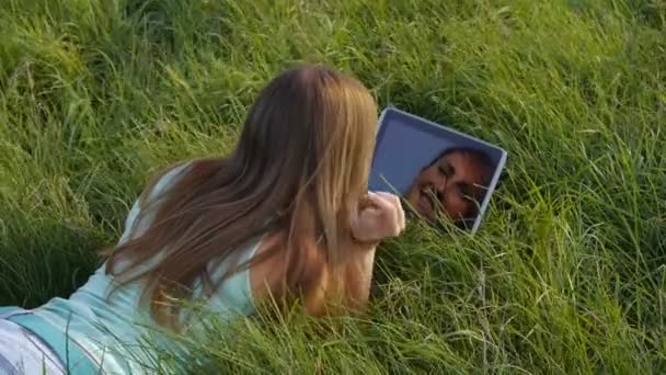 Brünette auf der Wiese mit digitalem Tablet — Stockvideo