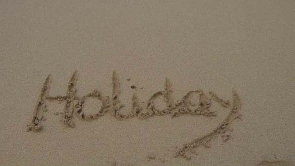 Mot vacances écrit dans le sable 