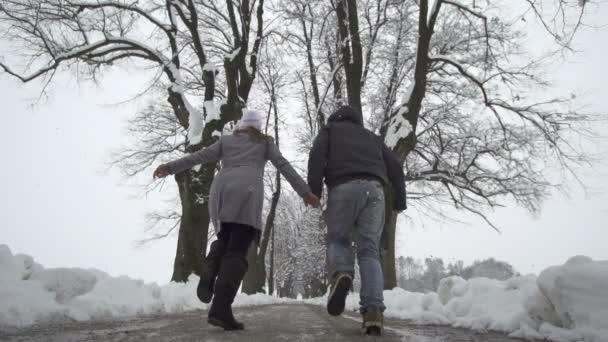 Пара біжить по зимовій набережній — стокове відео