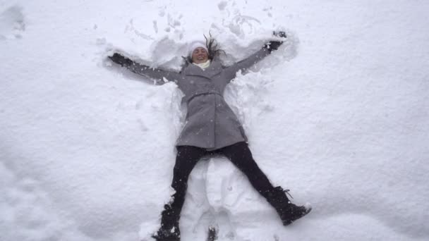 Woman making snow angels — Stock Video