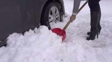 Araba kar kürekle kadın.