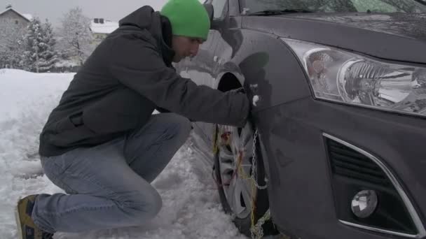 Człowiek wprowadzenie łańcuchy śniegowe na samochód — Wideo stockowe